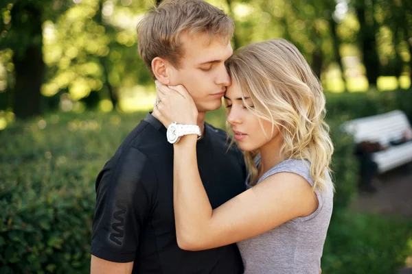 Romantische paar knuffelen in park op een zomerdag — Stockfoto