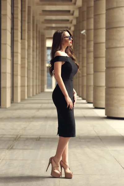 Stunning girl standing between columns — Stock Photo, Image