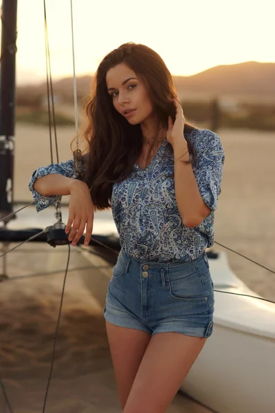 Joven hermosa chica bonita sentada en catamarán de vela — Foto de Stock