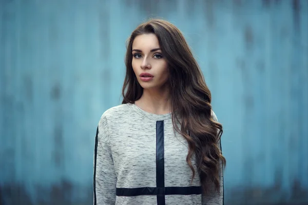 Pretty girl in hoodie against blue wall — Stock Photo, Image