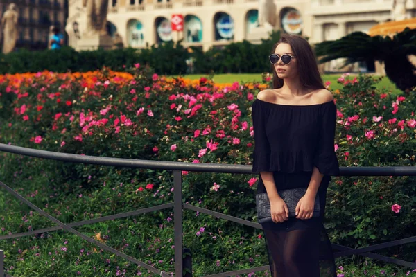 Chica joven contra las flores — Foto de Stock