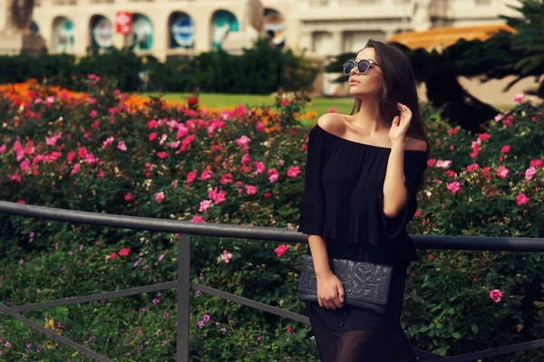 Chica joven contra las flores — Foto de Stock