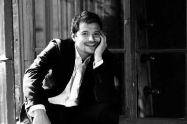 Siyah elbiseli mutlu gülümseyen adam