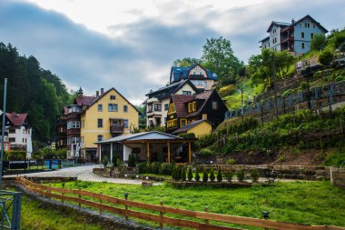 18 Mayıs 2019 Rathen, Saksonya, Almanya - Bastei Köprüsü 'nün karşısındaki Elbe nehri kıyısındaki küçük bir kasaba olan Kurort Rathen' da dar dağ yolları ve konut evleri
