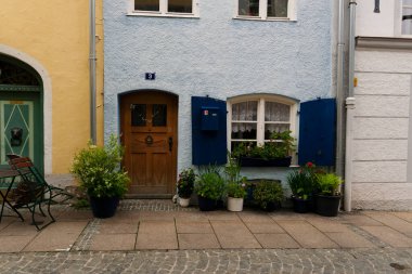 Fuessen, Almanya 26 Mayıs 2019 - Dağlar arasında yeşil yağmurlu vadide kaynamış kiremit çatılı sıcacık alp evleri. Küçük Alman kasabası Fussen.