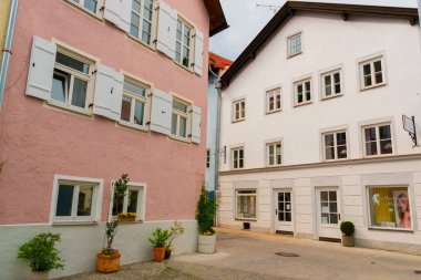 Fuessen, Almanya 26 Mayıs 2019 - Dağlar arasında yeşil yağmurlu vadide kaynamış kiremit çatılı sıcacık alp evleri. Küçük Alman kasabası Fussen.