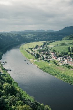 Bastei Köprüsü, Elbe Nehri ve Almanya 'nın Saksonya eyaletinde yer alan Bastei kumtaşı dağlarında Kurort Rathen kasabasının panoraması.