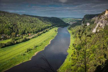 Bastei Köprüsü, Elbe Nehri ve Almanya 'nın Saksonya eyaletinde yer alan Bastei kumtaşı dağlarında Kurort Rathen kasabasının panoraması.