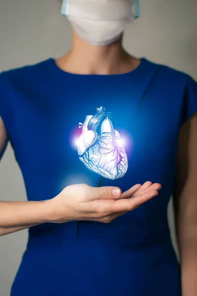 Woman in blue clothes holding virtual Heart in hand. Handrawn human organ, detox and healthcare, healthcare hospital service concept stock photo