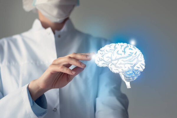 Женщина-врач касается виртуального мозга в руке. Размытое фото, раскрашенный человеческий орган, выделенный голубым как символ восстановления. Концепция медицинского обслуживания больницы фото на складе