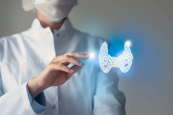Kadın doktor elinde sanal tiroid bezine dokunuyor. Bulanık fotoğraf, el yapımı insan organı, iyileşmenin sembolü olarak mavi işaretli. Sağlık hizmeti hastane konsepti stok fotoğrafı