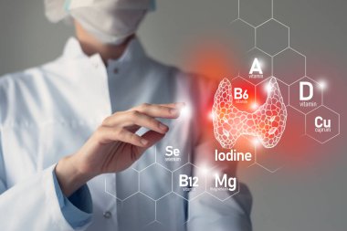 Tiroid bezi sağlığı için gerekli besinler iyot, Selenuim, B6 vitamini, Cuprum dahil. Doktorun kırmızı tiroid bezini tutan bulanık portresi.