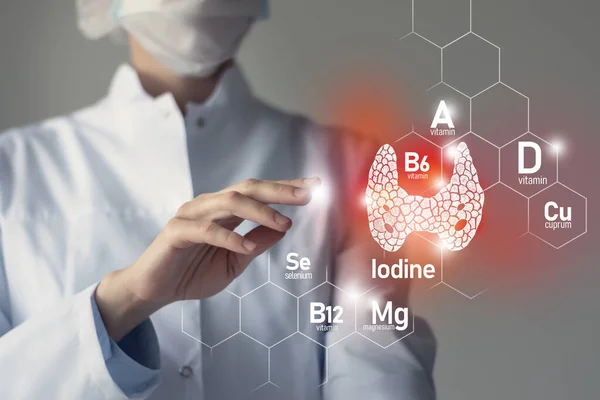 Tiroid bezi sağlığı için gerekli besinler iyot, Selenuim, B6 vitamini, Cuprum dahil. Doktorun kırmızı tiroid bezini tutan bulanık portresi.