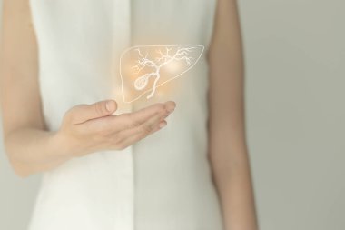 Beyaz elbiseli tanınmayan bir kadın hasta, ellerinde altı çizilmiş safra kesesi var. İnsan sindirim sistemi kavramı.