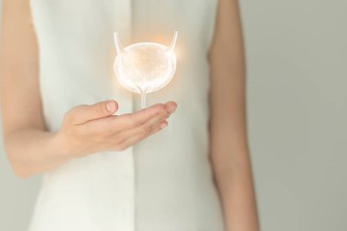 Beyaz elbiseli tanınmayan bir kadın hasta, ellerinde işaretlenmiş bir idrar torbası. İnsan böbrek sistemi kavramı.