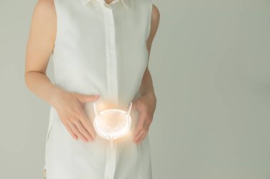 Beyaz elbiseli tanınmayan bir kadın hasta, ellerinde işaretlenmiş bir idrar torbası. İnsan böbrek sistemi kavramı.