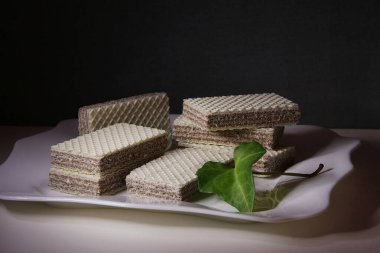 Kahverengi katmanlı beyaz gofretler beyaz tabakta yatıyor.