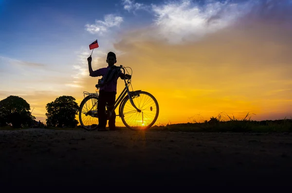 Silhouette garçon tenant le drapeau de la Malaisie — Photo