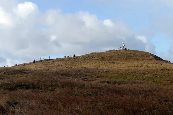 Turisté stoupání k památníku Albatros na mysu, postaven na počest námořníků, kteří zahynuli při pokusu zaokrouhlit mysu horn. — Stock fotografie