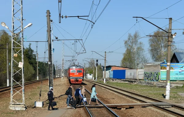 Ludzie przekraczania linii kolejowej. — Zdjęcie stockowe