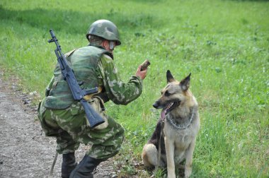 JURGA, SIBERIA, RUSSIA - 6 Haziran 2011: Patlayıcıları aramak için çoban köpeğiyle birlikte askeri köpek eğitmeni