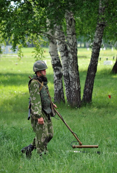 JURGA, SIBERIA, RUSSIA - JUNE 6,2011:Sapper with a metal detector examines the territory