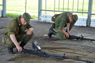JURGA, SIBERIA, RUSSIA - 9 Haziran 2011: Askerler ateş ettikten sonra bir tank makineli tüfeğini temizledi