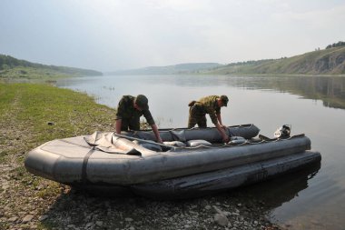 JURGA, SIBERIA, RUSSIA - 10 Haziran 2011: İstihkam askerleri geçişi güvence altına almak için kauçuk bir bot hazırlıyorlar