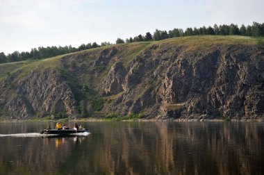 JURGA, SIBERIA, RUSSIA - 10 Haziran 2011: İnsanlar Batı Sibirya 'daki Tom Nehri' nde şişme bir tekneye biniyorlar