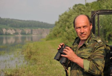 YURGA, SIBERIA, RUSSIA-JUNE 10 Haziran 2011: Batı Sibirya 'daki Tom Nehri kıyısında dürbünlü bir mühendislik biriminin çavuşu