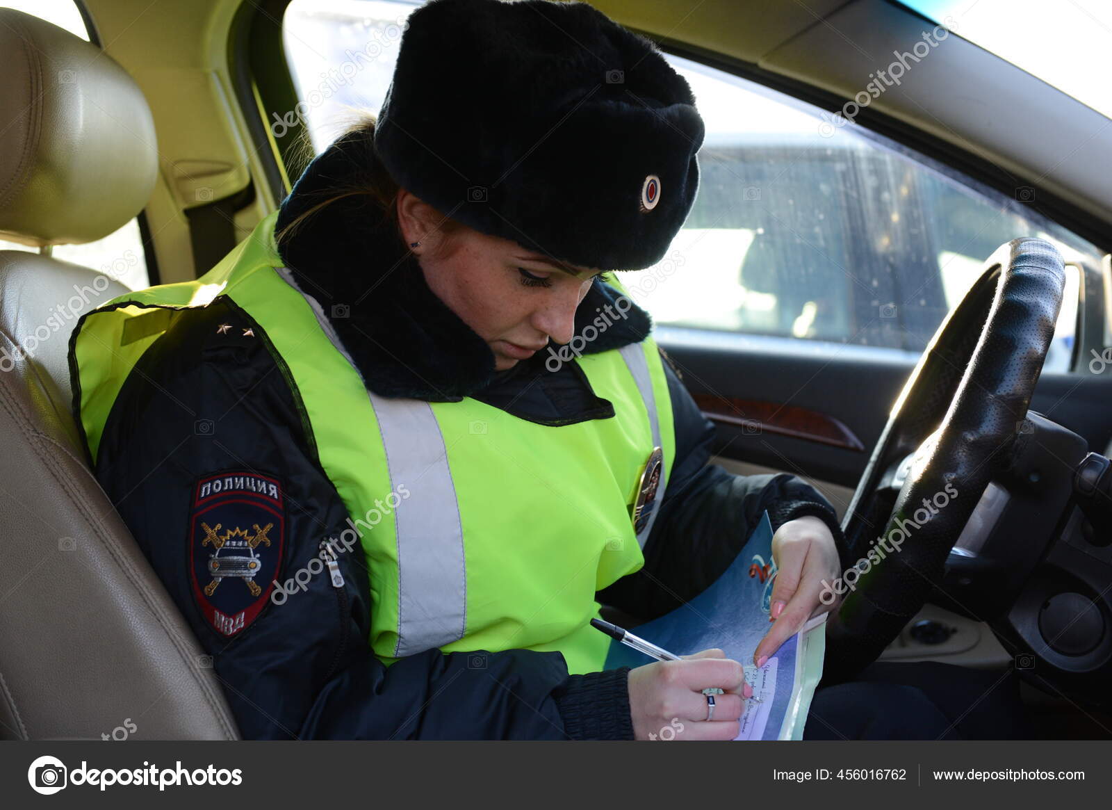 инспектор гаи. полицейская машина внутри. остановил сотрудник дпс. находиться инспектор. машина на парковке.