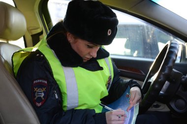 ODINTSOVO, MOSCOW REGION, RUSSIA - 20 Şubat 2016: Polisin yol devriyesi müfettişi trafik kurallarının ihlali hakkında bir protokol hazırladı