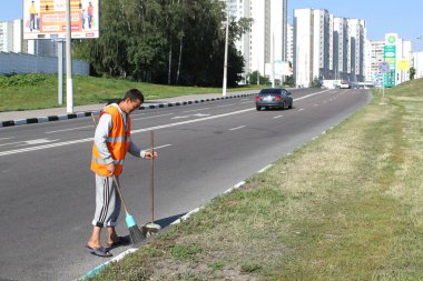 MOSCOW, RUSSIA-JULY 30, 2012:A migrant worker cleans a street in Moscow clipart