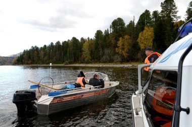 ALTAI REPUBLIC, RUSSIA - 27 Eylül 2020: Bir ulaşım polisi Teletskoye Gölü 'ndeki bir gemi müdürüyle konuşuyor. Altai Cumhuriyeti