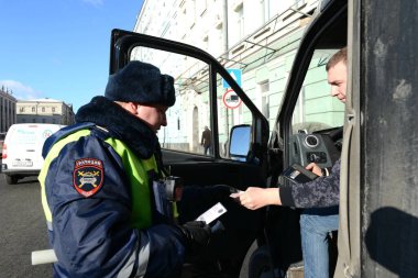 MOSCOW, RUSSIA - 15 Şubat 2017: Polis yol devriyesi müfettişi durdurulan aracın sürücüsünün belgelerini kontrol ediyor