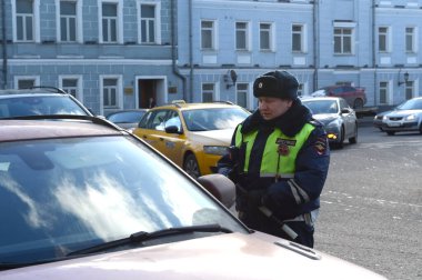 MOSCOW, RUSSIA - FEBRUARY 15, 2017:An inspector of the road patrol service of the police talks with the driver of a stopped car in the center of Moscow