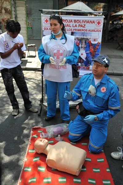 Gli attivisti della croce rossa insegnano alle persone il primo soccorso in una strada della città . — Foto Stock