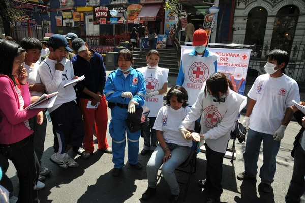 Gli attivisti della croce rossa insegnano alle persone il primo soccorso in una strada della città . — Foto Stock