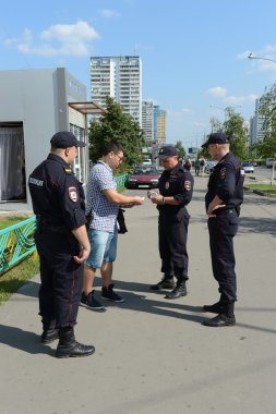 Polis memurları Moskova sokaklarında belgeleri denetleme.