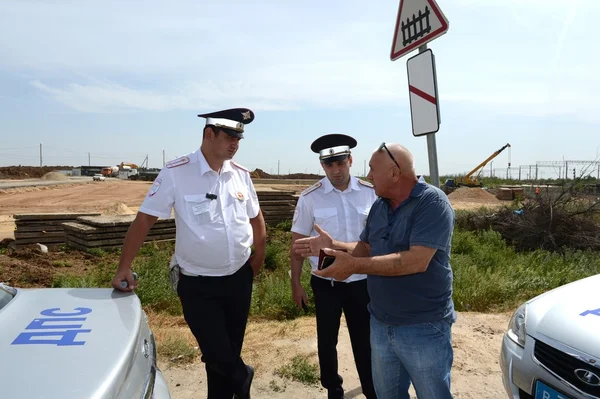Yol üzerinde trafik polisi müfettişleri ile bir sürücünün konuşma.