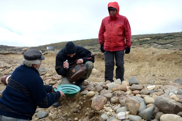 Zlatokop ukazuje turisté lužní zlatého písku těžen v dole na ostrově Tierra del Fuego. — Stock fotografie