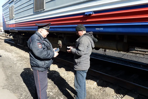 Los empleados de la policía de transporte durante un RAID en el ferrocarril en Moscú echa un vistazo a la base de datos de información ciudadana . — Foto de Stock