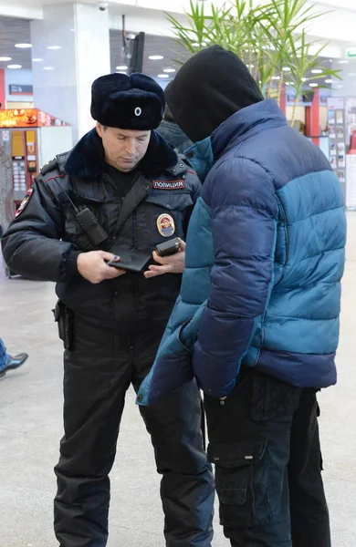 A police officer checks the national database informacionnoi at the entrance to Paveletskaya station. — Stock Photo, Image