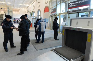 Bir polis memuru Paveletskaya İstasyonu girişinde ulusal veritabanı informacionnoi denetler.