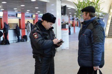 Bir polis memuru Paveletskaya İstasyonu girişinde ulusal veritabanı informacionnoi denetler.