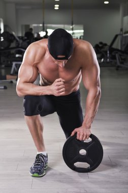 Egzersiz kilo ile hazırlama yakışıklı güçlü atletik bir adam. Mükemmel, omuzlar, kollar ve göğüs ile güçlü vücut geliştirmeci.