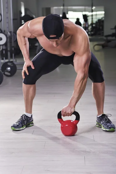 Bonito homem atlético poderoso realizando exercício de sino de chaleira . — Fotografia de Stock