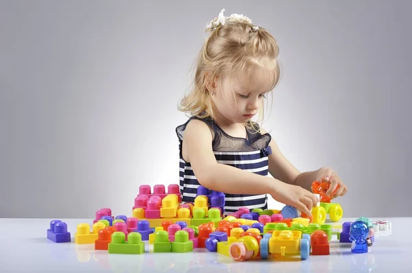 Portretul unei fetițe frumoase care se joacă cu cuburi de jucărie din plastic — Fotografie, imagine de stoc