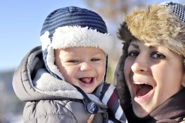 Mutlu bir aile. Tatlı bebeği ile bir kış parkta genç anne 