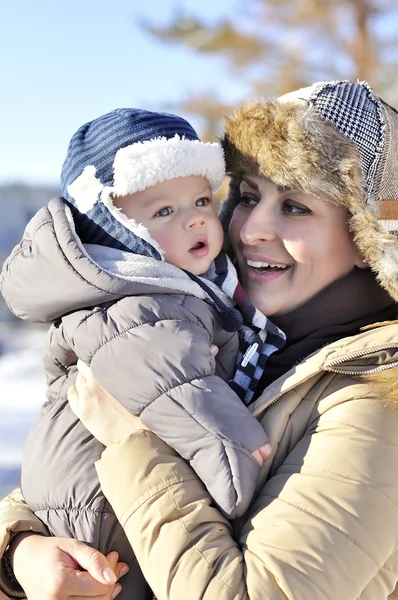 Família feliz. Jovem mãe em um parque de inverno com seu bebê doce — Fotografia de Stock